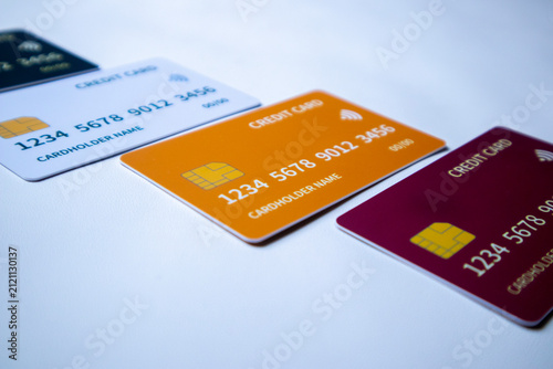 Macro angled diagonal sequence of multi-colored credit and debit cards on a white surface