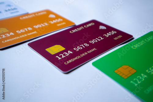 Macro angled diagonal sequence of multi-colored credit and debit cards on a white surface