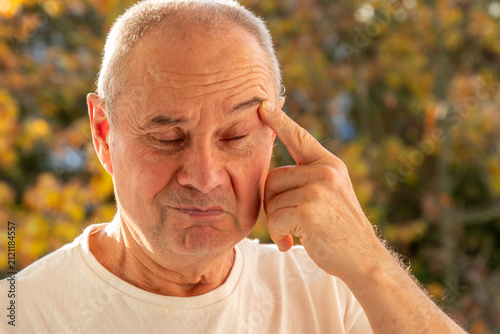 Obraz na plátne mature male face man 50-55 years old, looks examines wrinkles around eyes, skin