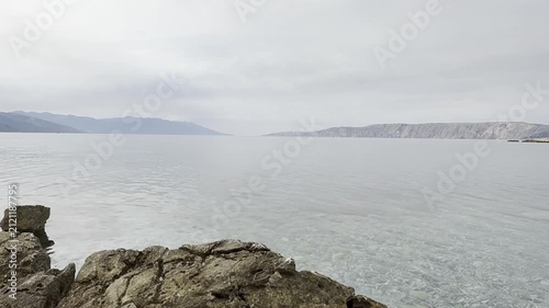 Gentle Adriatic Sea waves over rocky coastline in Novi Vinodolski, Croatia