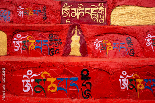 Принти на полотні Inscriptions and a stupa carved into a red wall along the kora, a pilgrimage path in Dharamsala, Himachal Pradesh, India