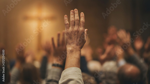 Silhouetted hands raised in spiritual praise and worship at church