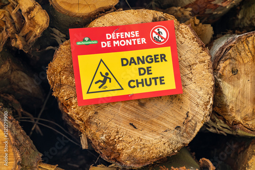 Exploitation forestière. Rondins de bois empilés. Pancarte d'avertissement Défense de monter, danger de chute. Pins sylvestre