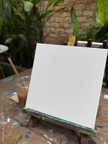 Bild auf Leinwand blank small canva frame on table in the garden