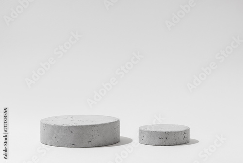 Two Concrete Cylinder Podiums of Different Sizes on Light Gray Background with Copy Space for Product Mockups.
