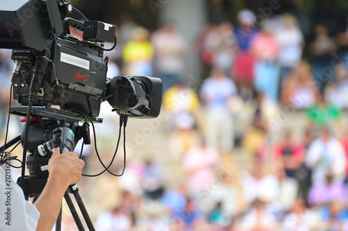 Professional TV camera broadcasting a live event with blurred crowd in the background
