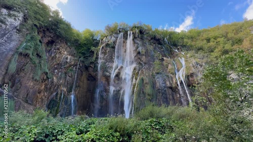 Plitvica Selo, Croatia - October 06, 2025: Plitvice Lakes National Park, Croatia. Waterfall cascading into tranquil lake surrounded by lush greenery and rocky formations in serene natural setting
