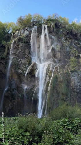 Plitvica Selo, Croatia - October 06, 2025: Plitvice Lakes National Park, Croatia. Waterfall cascading into tranquil lake surrounded by lush greenery and rocky formations in serene natural setting