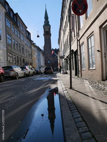 Obraz na płótnie Reflection of a historic clock tower in a puddle on a Copenhagen street in Denma