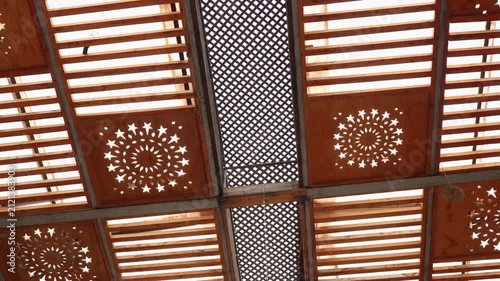 Decorative Wooden Ceiling Panels With Geometric Star Cutouts and Lattice Pergola Allowing Warm Sunlight