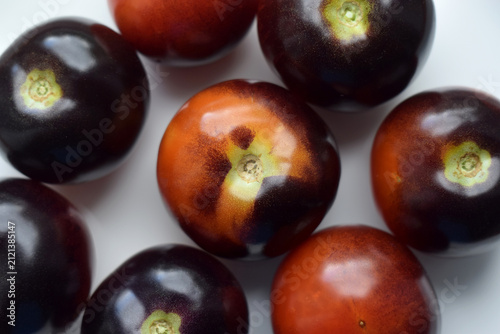 Black and red tomatoes on a white plate.