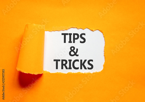 Tips and tricks words symbol. Concept words Tips and tricks on beautiful white paper. Beautiful orange background. Business tips and tricks motivational support concept. Copy space.