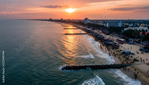 High angle view of busy rk beach at sunset in visakhapatnam with crowds along the coastline for a coastal tourism concept with golden light over ocean waves