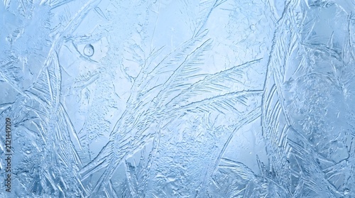 Frost patterns cover the cold window pane during a crisp winter morning.