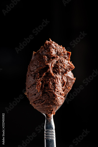 Obraz na płótnie spoonful of chocolate icing on black background