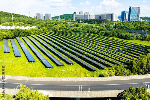 Solar panel farm near modern buildings and road