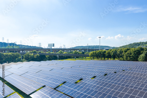 Solar panels with highway and green hills in distance