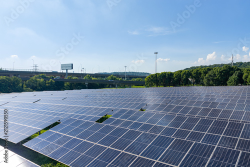 Photovoltaic array beside road and tree line