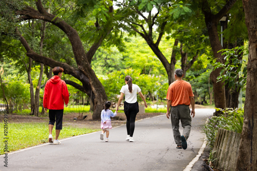 Obraz premium Backview Family exercising and jogging together in city park summer. healthy lifestyle in nature. Father mother, kids daughter exercise. Family team, children. healthy lifestyle and family bonding