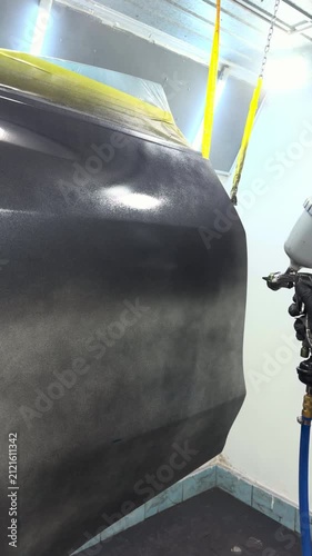 Automotive door receiving a new paint coat in a professional spray booth