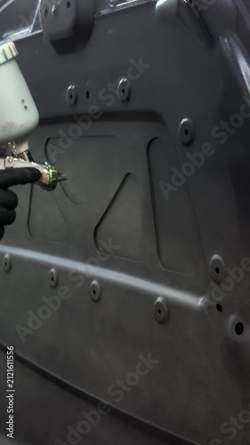 Professional car hood painting process in a clean workshop environment