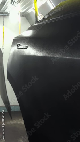 Automotive door undergoing professional spray painting in a clean workshop