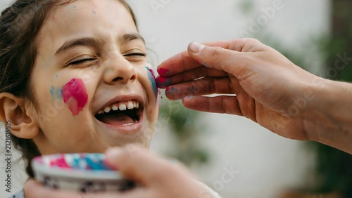 Child Getting Face Painted by Artist Outdoors with Bright Smile