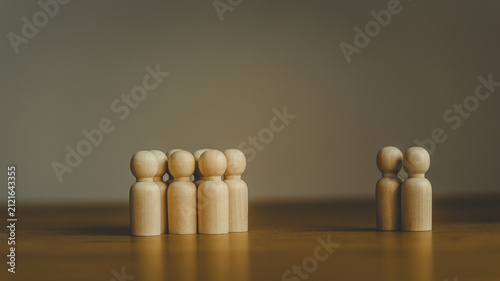 Картината върху платно Wooden peg figures representing a group separated from a couple on a wooden surf