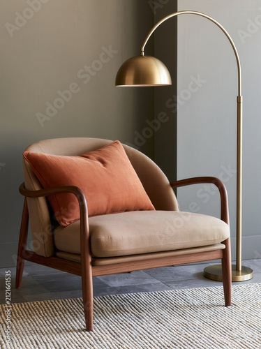 Curved walnut lounge chair with brass floor lamp in elegant organic modern interior