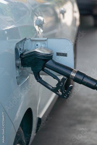 Canvastavla car diesel fuel nozzle inserted in vehicle tank closeup black dispenser held by