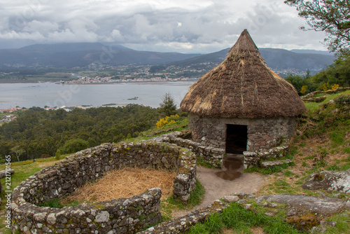 Quadro su tela Ancient Celtic ruins of Castro de Santa Trega with a traditional thatched roundh