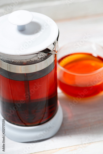 fresh black tea in French press on white background, top view