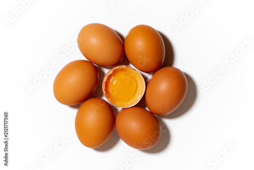fresh chicken eggs on white background, one broken egg, closeup top view