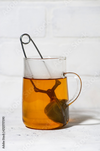 glass cup with brewing black tea, vertical