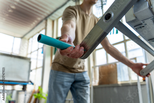 Fotografie Male craftsman holding the handle of an industrial glass fusing kiln or furnace in a glassmaker workshop, preparing equipment for heat treatment