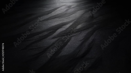 Dark graphite texture shimmering under soft top light background animation