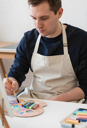 Young man in an apron paint...