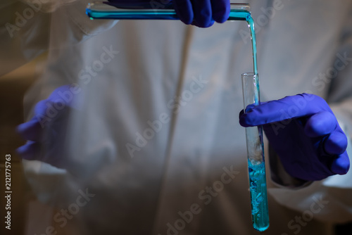 Female chemistry scientist doing experiments in lab.