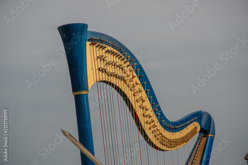 Hands playing the strings of a classical harp