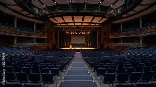 Modern Auditorium Stage With Empty Blue Seats And Podium Ready For Presentation