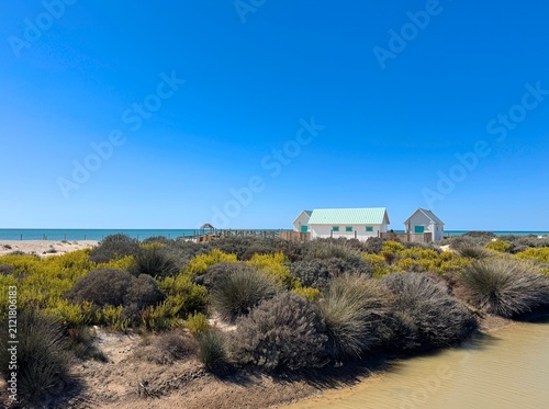 Obraz na płótnie View over dunes and brackish land to white turquoise beach huts at the Playa de