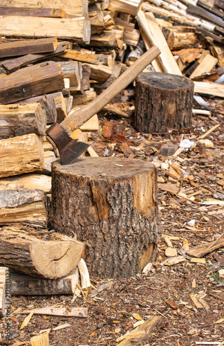large stack of firewood with axe.