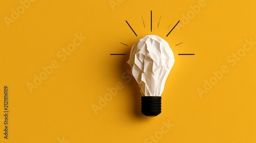 Crumpled paper lightbulb on yellow background representing creative idea and innovation