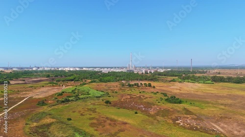 Oil refinery and green landscape in Sines, Portugal. Aerial view, distant shot. Moving forward