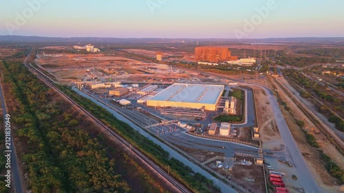 Data center building and expansion site under construction near the coastline in Portugal at sunset. Green landscape. Aerial view. Moving forward