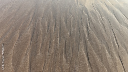 Quadro su tela Intricate wet sand ripples forming natural patterns on a shoreline surface