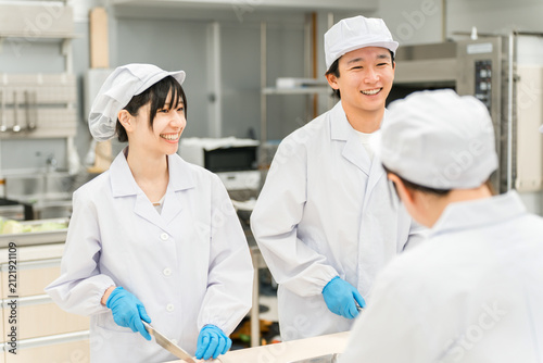 Fotografie Male and female staff in chef's coats preparing fish (cooks, chefs, fresh food m
