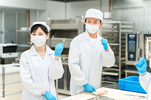 Obraz na plátně Male and female staff in chef's coats preparing fish (cooks, chefs, fresh food m