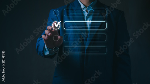 Принти на полотні Businessman touches virtual screen interface to select an option on the digital checklist