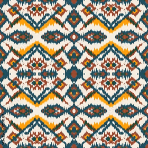 Seamless ethnic ikat pattern with bold teal blue, yellow, and terracotta geometric diamond motifs on an ivory background. Tribal fabric design perfect for bohemian prints, wallpaper, and decor.